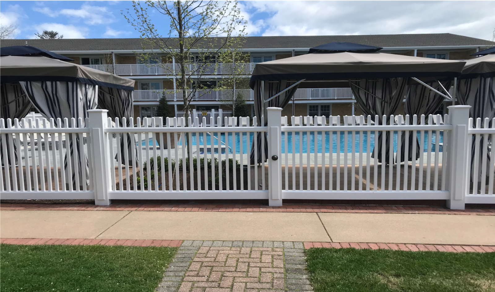 Cellular PVC fencing surrounding a pool.