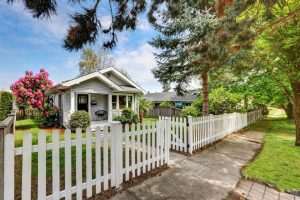 A white picket fence surrounding a house.